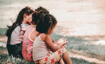 Three children sitting on grass